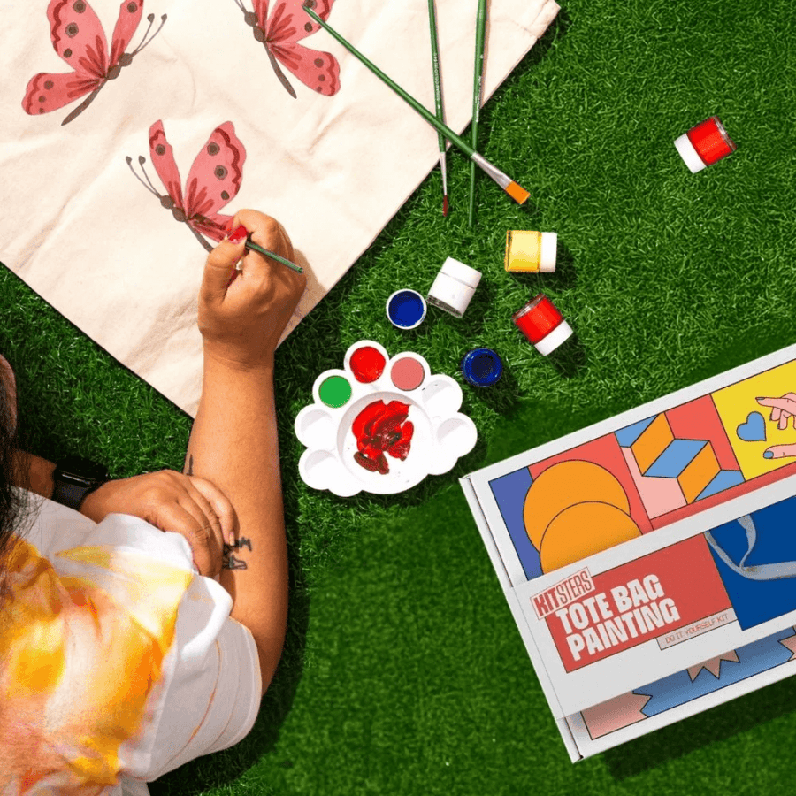 Hands mid-make, painting a tote bag at a Kitsters workshop station